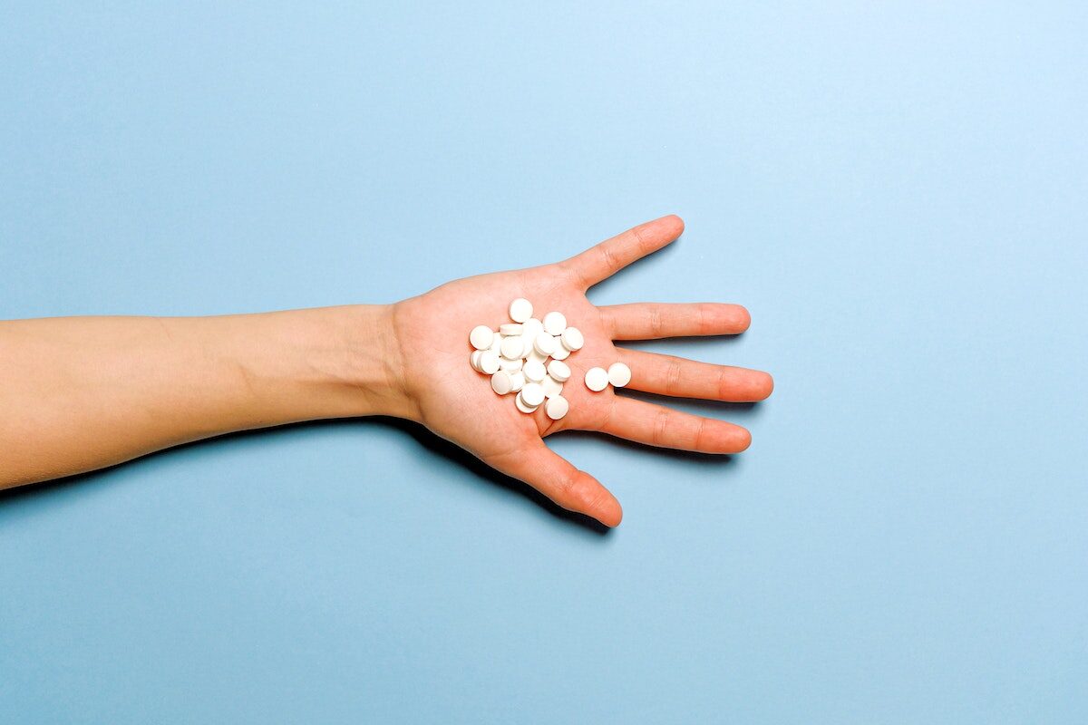 Person Holding White Round Medication Pills