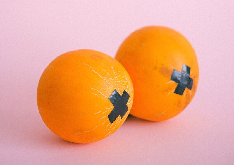 Ripe oranges with black tape crosses