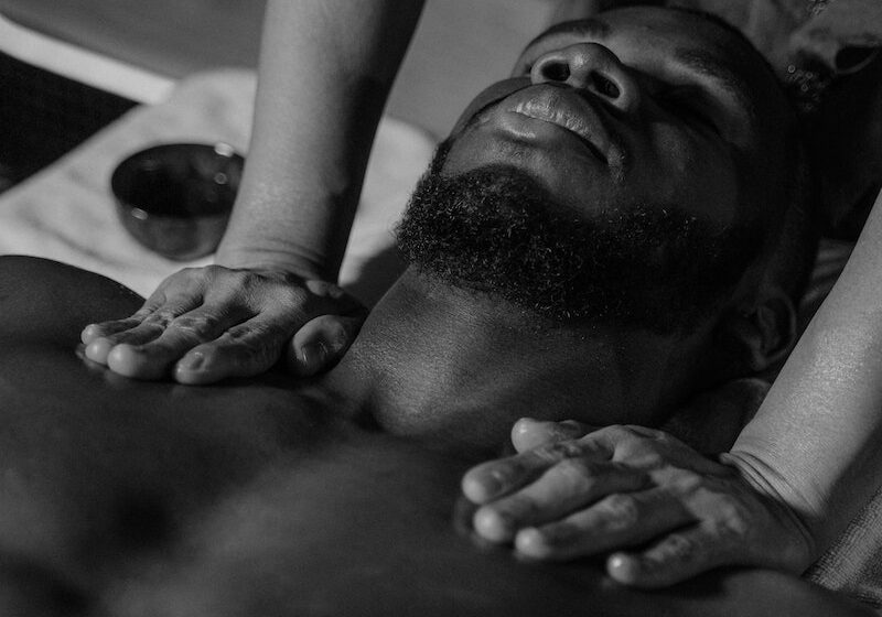 Hands Massaging Male Body Lying on Massage Table